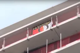 Rotterdamse bouwvakkers hangen Feyenoord-vlag op in Amsterdamse woontoren