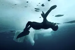 Superwoman zwemt onder het ijskoude poolijs