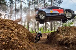 Rallycar en mountainbiker doen wedstrijdje wie het eerst beneden is