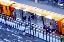 Gasten spuiten in strak geplande actie een enorm kunstwerk van graffiti op een treinstel