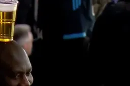 Man balanceert biertje op zijn hoofd tijdens Champions League potje