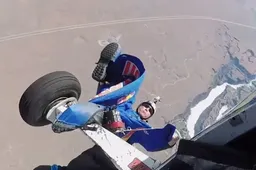 Dude blijft met zijn wingsuit aan het vliegtuig hangen