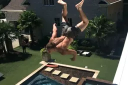 Dudes flikflakken vanaf een dak in het zwembad