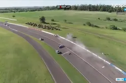 Car flies over crash barrier in banked turn during touring car race in Argentina