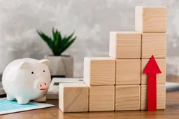 piggy-bank-with-wooden-growth-blocks-arrow-pointing-up