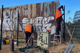 Werken aan een beschilderd hekwerk