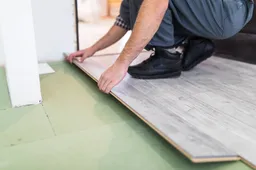 worker-processing-floor-with-laminated-flooring-boards