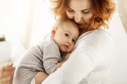 beautiful-young-mother-tenderly-hugs-her-little-cute-child-mom-looking-her-kid-smiling-while-baby-looks-aside-snuggling-mom-chest-happy-family-moments