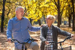 happy-elderly-couple-riding-bicycle-park-autumn