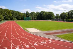 Zonnig atletiekstadion met discuskooi
