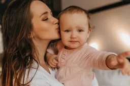 portrait-woman-white-home-clothes-her-blue-eyed-baby-lady-lovingly-kisses-her-daughter