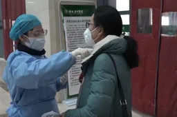 A nurse measuring the body temperature for outpatients in Hubei TCM Hospital