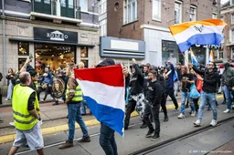 Demonstranten geflankeerd door politie gestart met mars Amsterdam