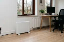 Illustratie van een elektrische kachel in een werkkamer, rechtstreeks aangesloten op een wandstopcontact.