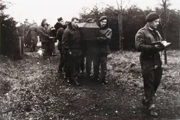 Father Daniel McGowan (rechts) leidt een begrafenisdienst in krijgsgevangenenkamp Dulag Luft. Gelders Archief 2867 289.