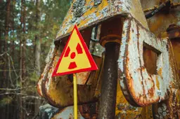 Een geel waarschuwingsbord voor straling staat tussen de bomen in de sperzone rond Tsjernobyl.