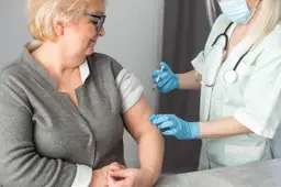Close-up verpleegkundige die vaccininjectie doet aan oudere vrouw.