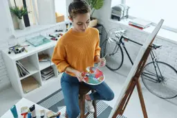 Top uitzicht van mooie jonge vrouw mengen kleuren tijdens het tekenen in kunst studio