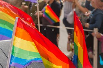 Deugpresentator KRO-NCRV deelt regenboogvlaggen uit aan afreizende Oranjesupporters: 'blij om een statement te maken'