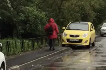 Dame met stok geen liefhebber van op de stoep geparkeerde auto