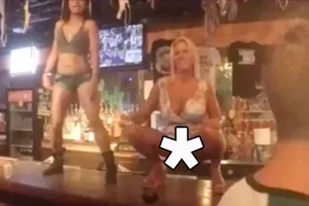 Dame en heer beoefenen liefdesspel in volle kroeg