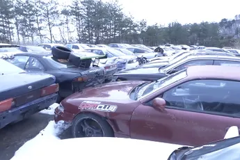 Een kijkje op een soort van kerkhof waar drift auto's staan