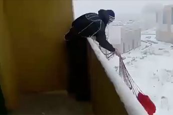 Gekke Rus springt met parachute van balkon van flatgebouw