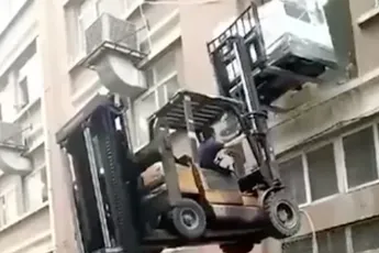 Twee heftrucks proberen een wasmachine te bezorgen...