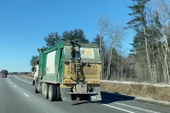Wasbeer krijgt een lift van een vuilniswagen