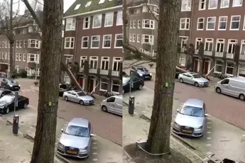 Boom valt door storm Eunice op achterkant van rijdende auto in Amsterdam