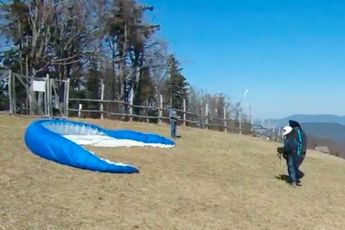 Windhoos slingert paraglider de bomen in