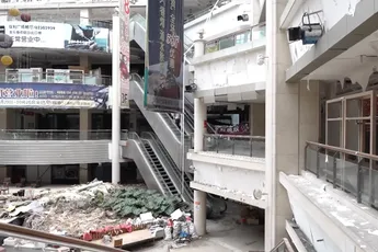 Beveiliger kijkt rustig naar natuurfilm terwijl Urban Explorers verlaten winkelcentrum bekijken