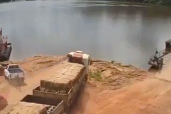 Vrachtwagenchauffeur net op tijd uit wagen voor deze plons in rivier maakt
