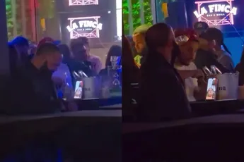 Kerel geniet van paar biertjes met vrienden, vriendin houdt oogje in het zeil via FaceTime