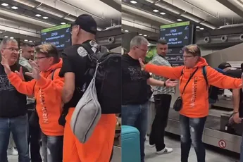 Vrouw bij de bagageband op vliegveld laat haar kortpittige kapsel gelden