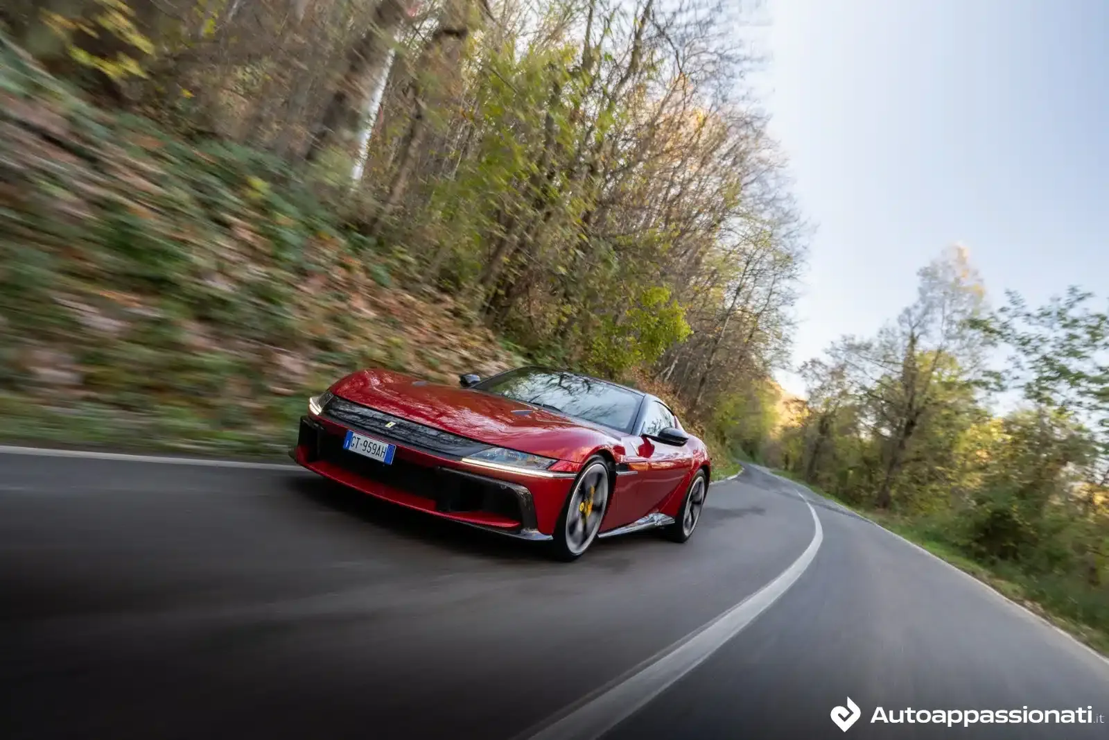 ferrari 12cilindri rossa percorre una strada in velocità