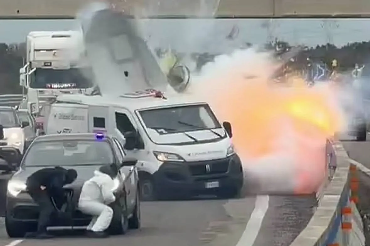 immagine che ritrae un portavalori assaltato sulla brindisi lecce. si vede esplosione di un furgone bianco dietro a un'auto e due uomini armati