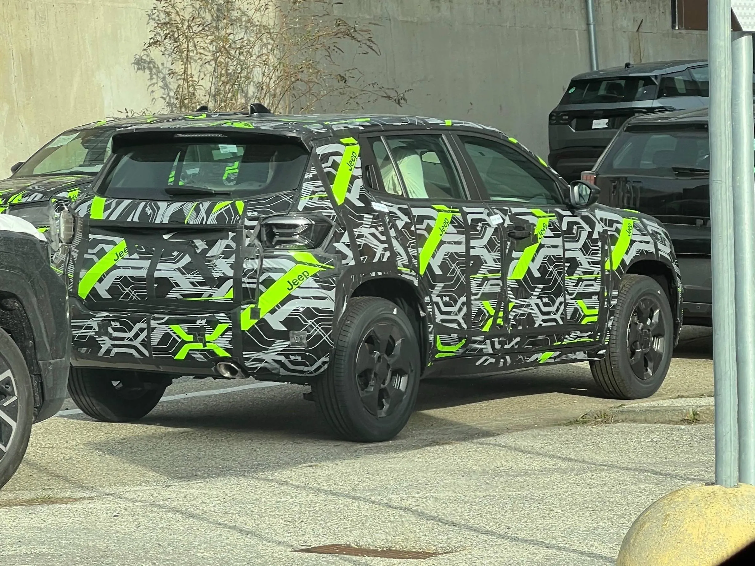 Jeep Avenger 2027 camuffato di colore grigio e verde flash in posizione posteriore parcheggiato