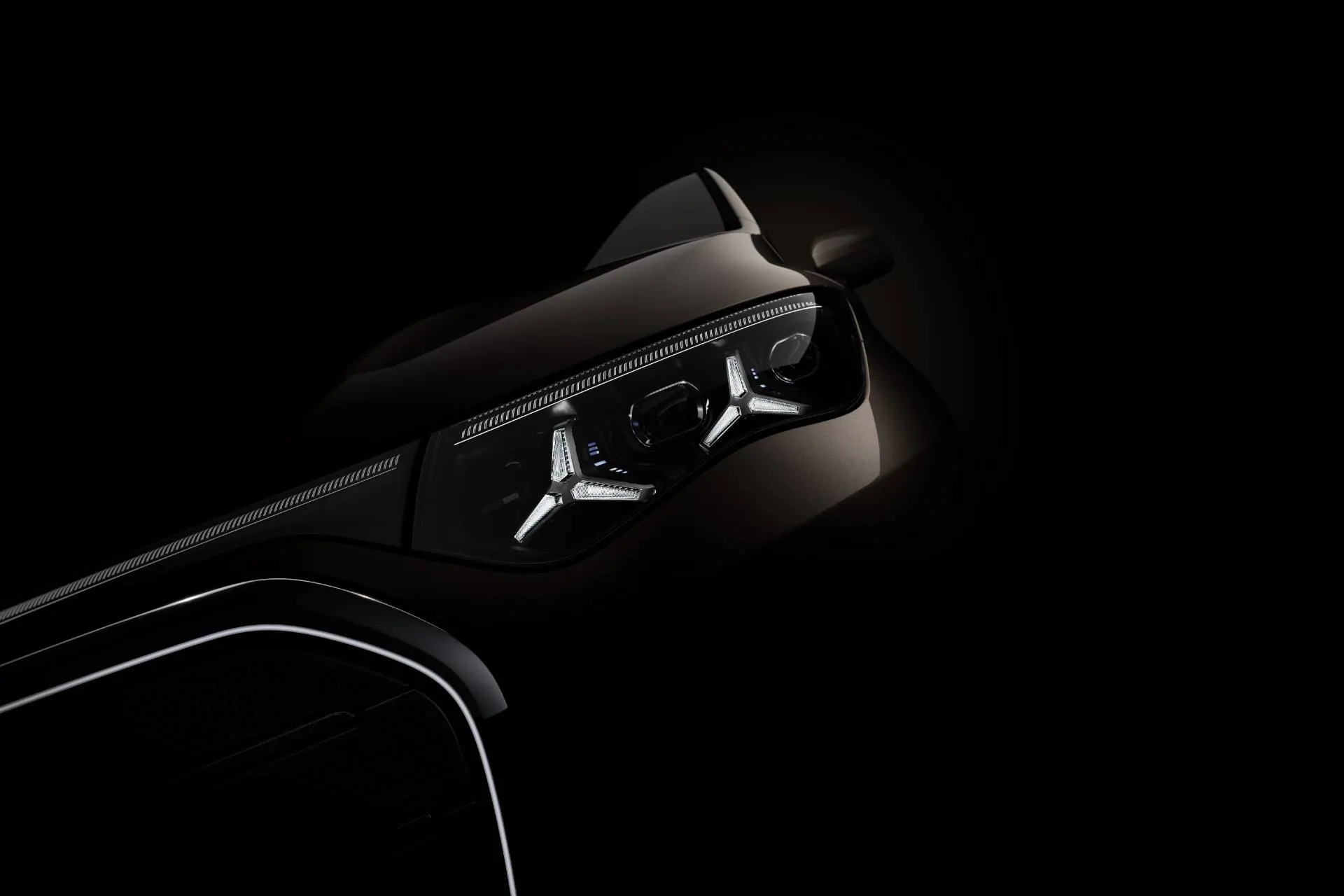 sfondo buio si vede solo il faro sinistro di una mercedes di ultima generazione che riproduce il logo mercedes della stella a tre punte