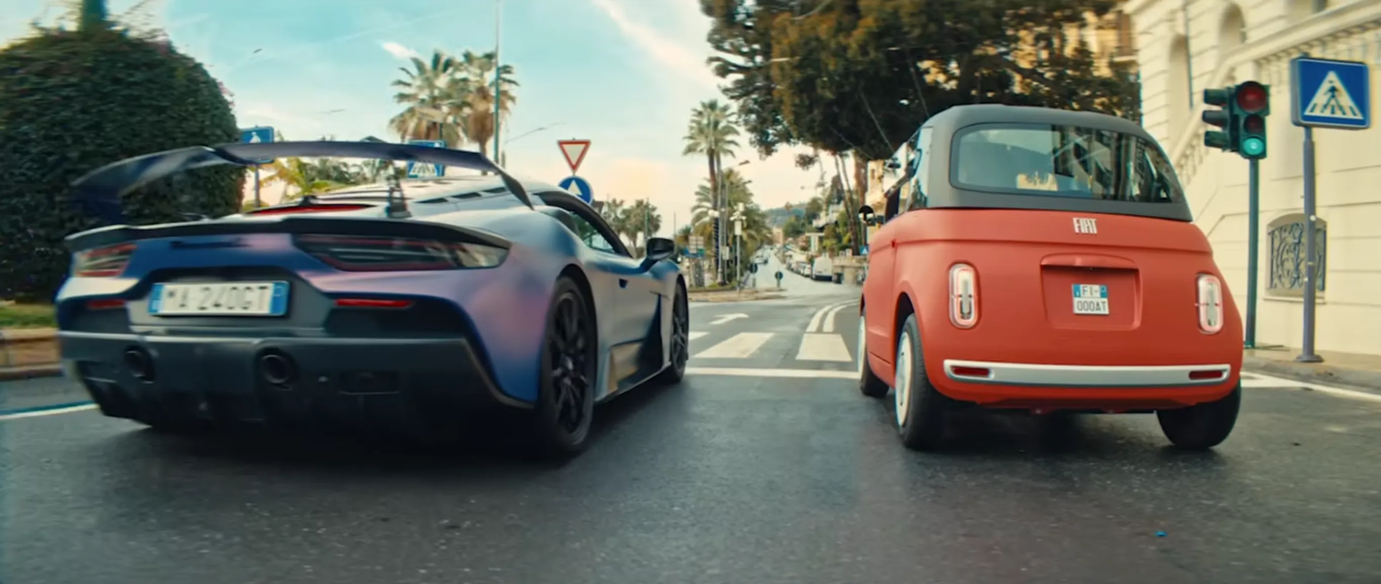 Vista posteriore della Maserati GT2 Stradale che affianca la Fiat Topolino Corallo; in evidenza l'aggressivo diffusore e l'imponente alettone in fibra di carbonio della supercar modenese