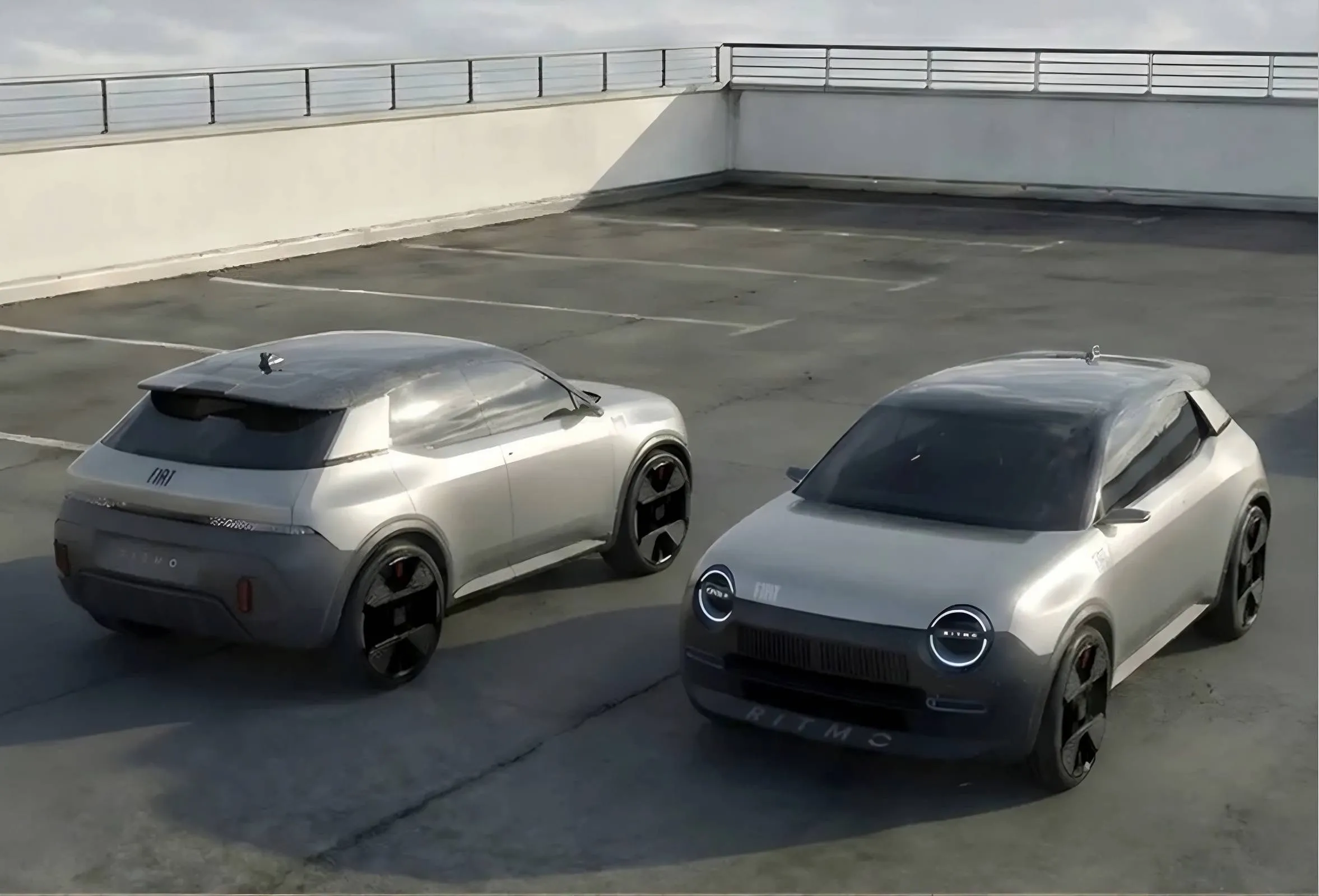 Due render digitali della nuova Fiat Ritmo color argento parcheggiati su un tetto. L'immagine mostra contemporaneamente il design del frontale con fari circolari e il volume posteriore massiccio e sportivo