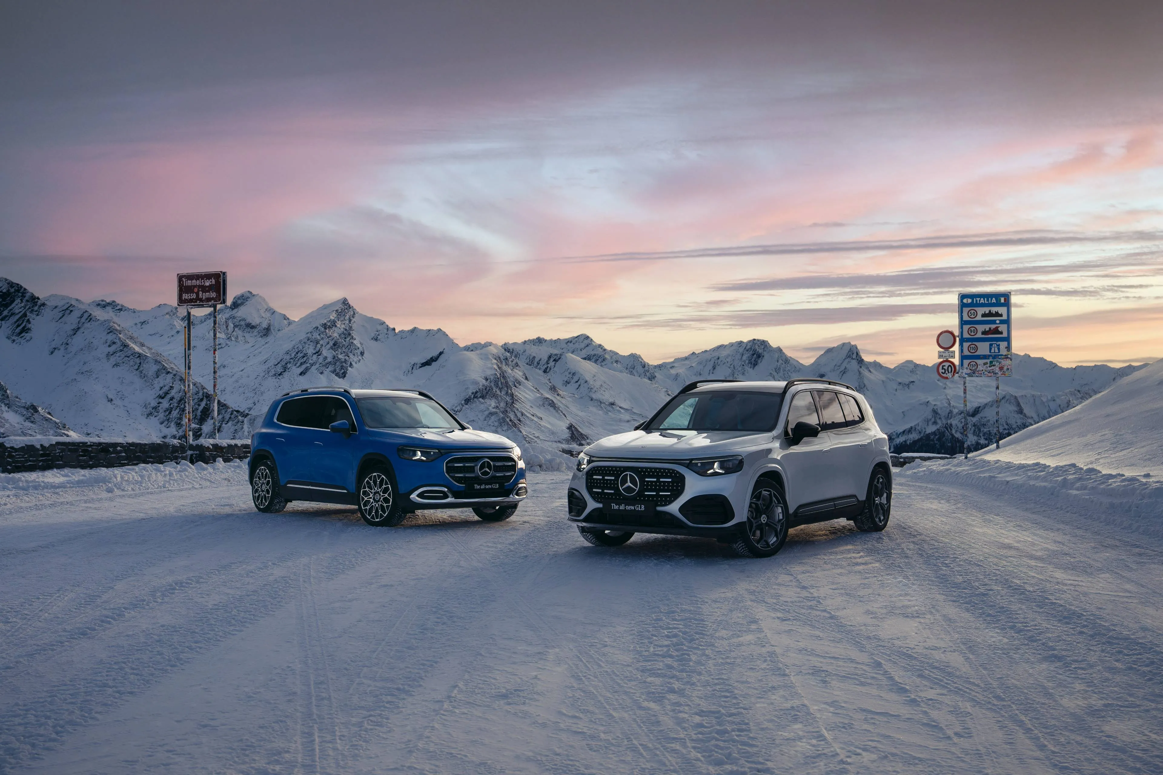 Mercedes GLB Hybrid in due versioni parcheggiate una affianco all'altra al tramonto sulla neve