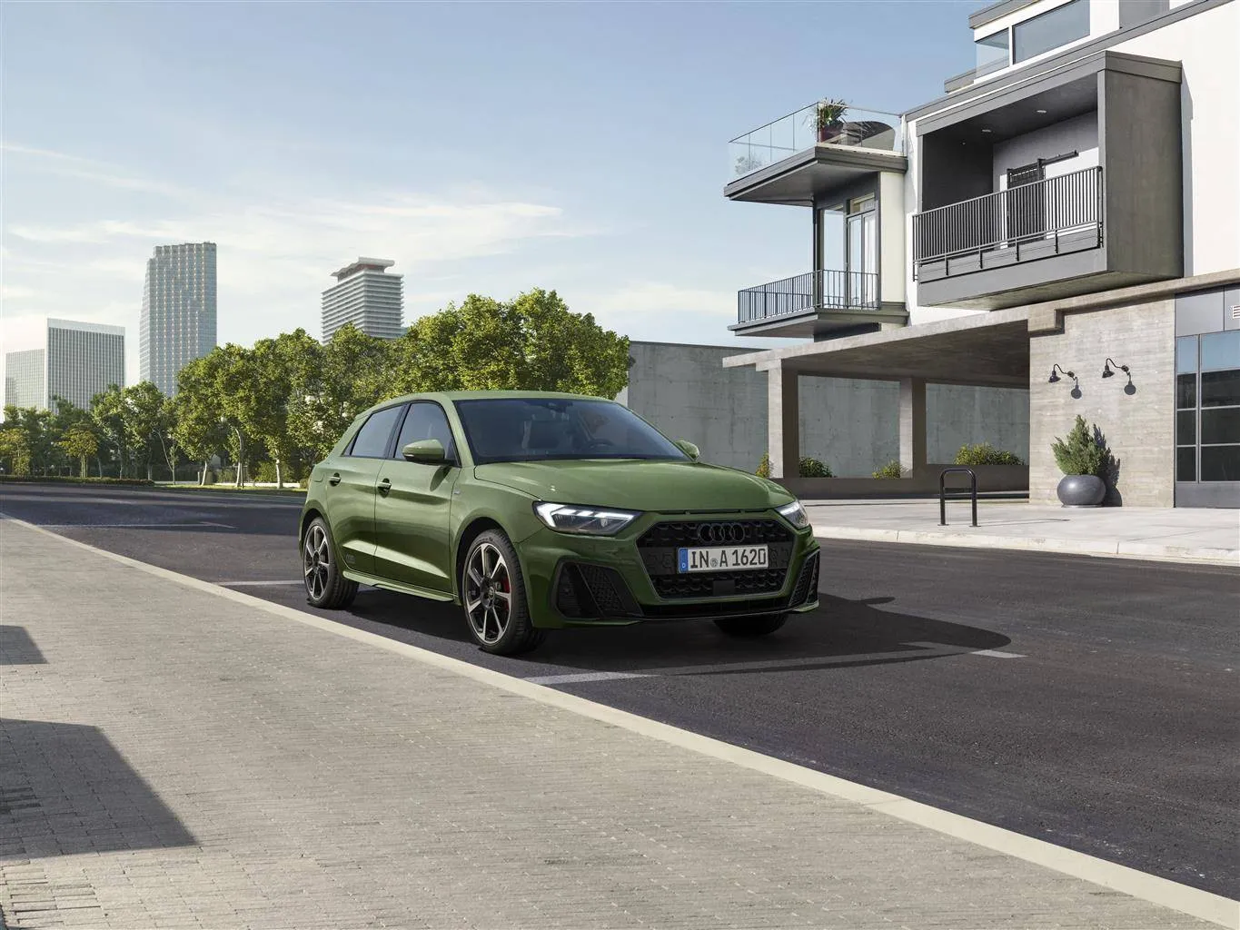 audi a1 di colore verde parcheggiata per strada con palazzo alla spalle