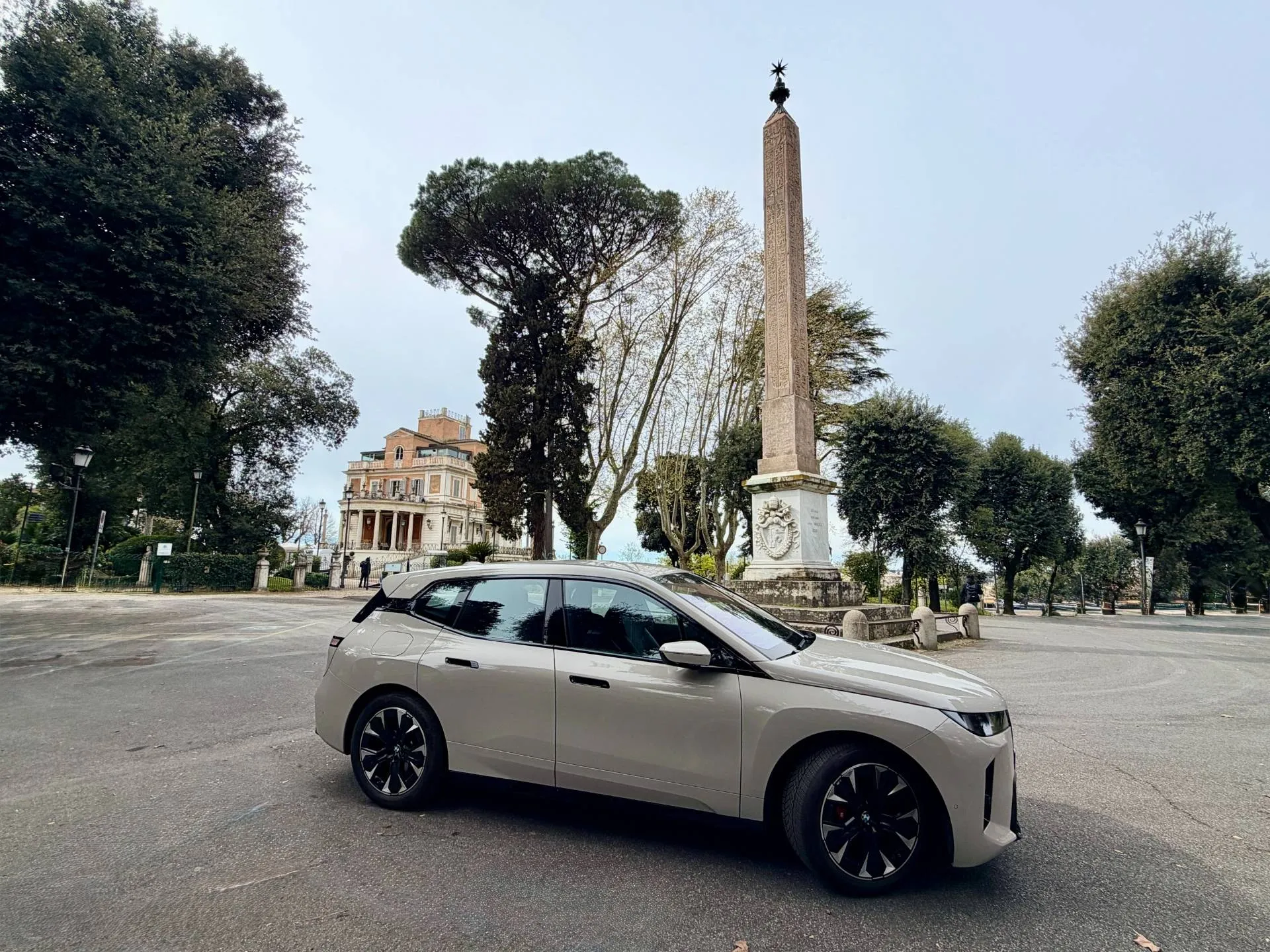 Una bmw ix a roma in piazza parcheggiata di lato e di colore beige