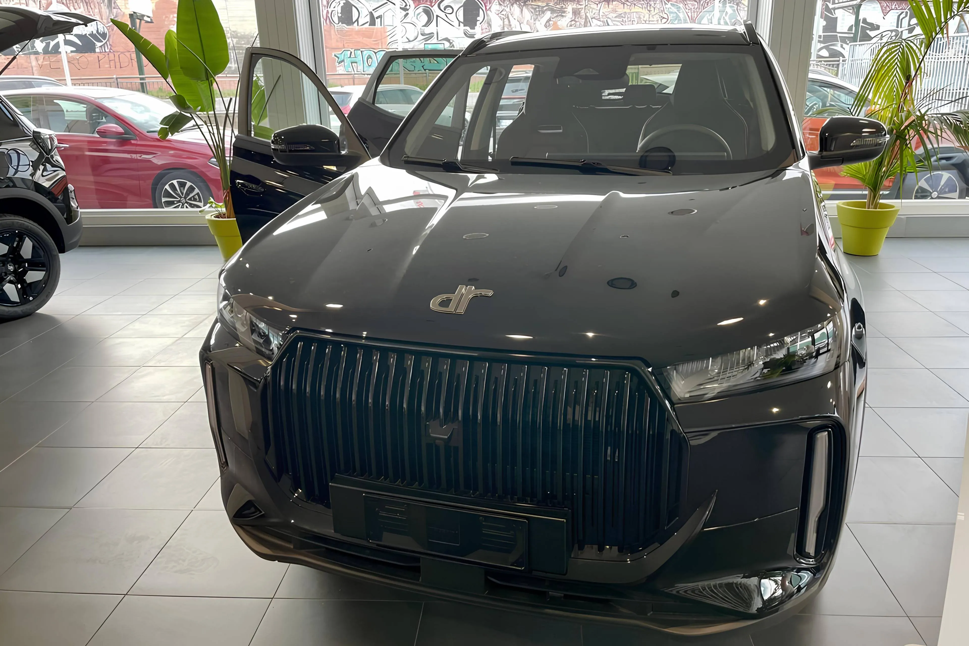 SUV DR 5 CINESE IN SHOWROOM NERA CON SFONDO CHIARO E PIANTE