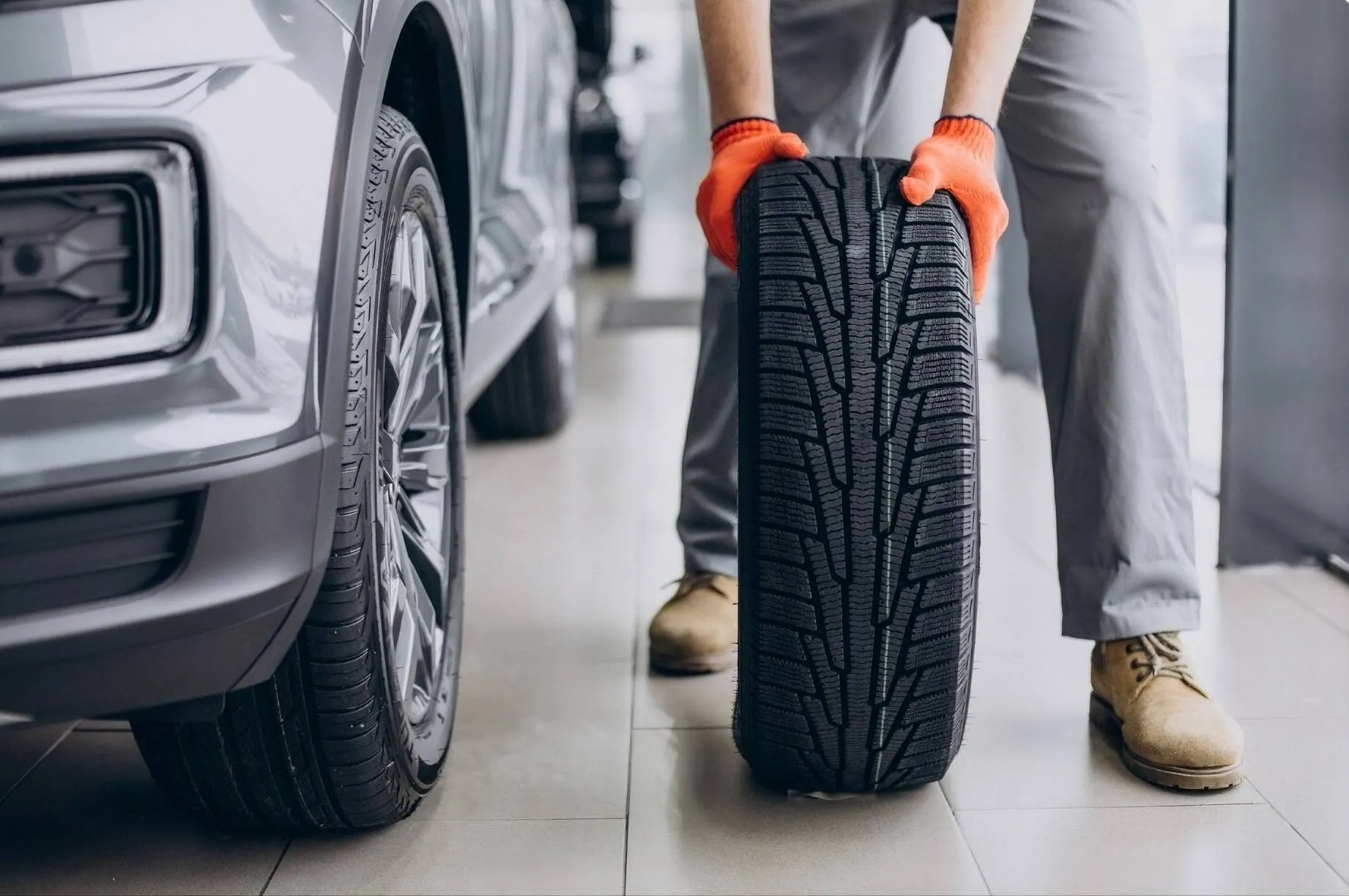 pneumatici-battistrada uomo che tiene pneumatico in mano