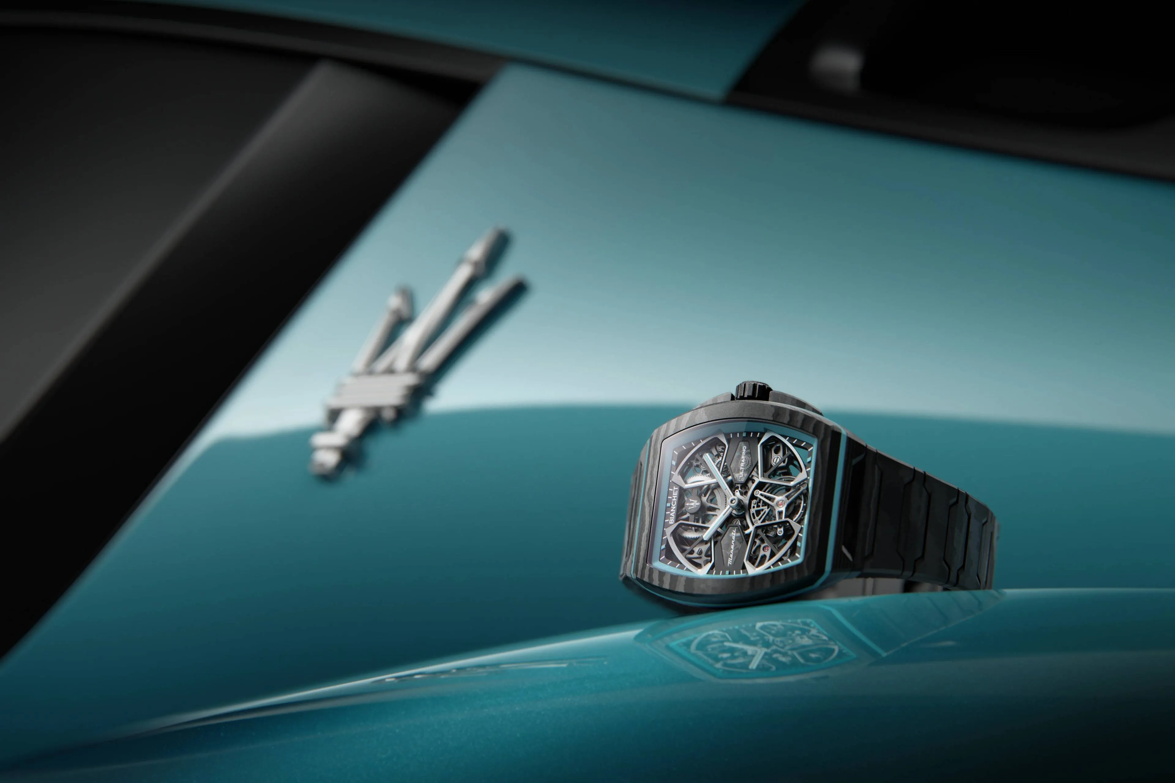 UltraFinoMaserati orologio su carrozzeria della maserati di colore azzurro con sfondo logo maserati