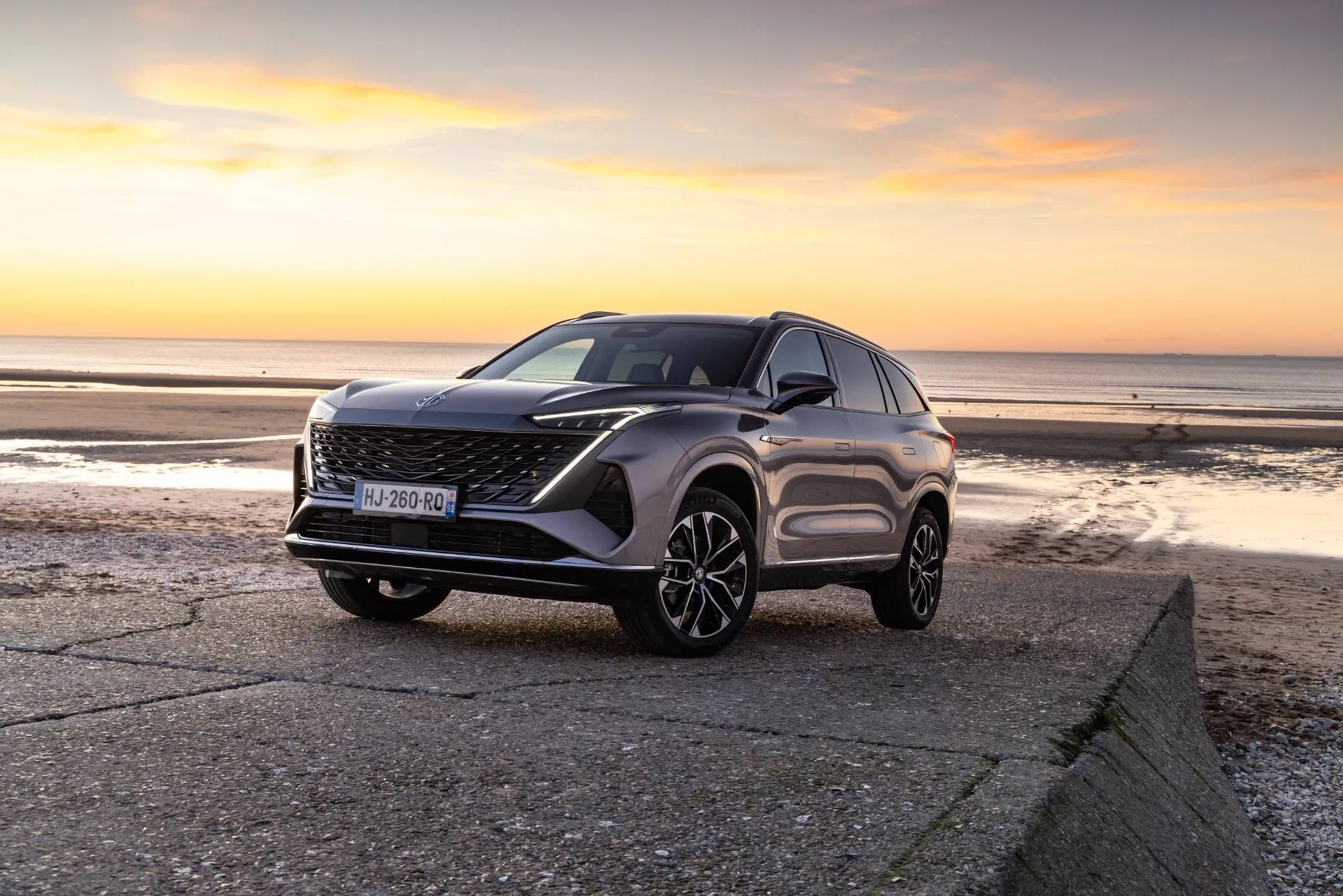 mgs9_phev anteriore di colore grigio al tramonto con il mare alle spalle