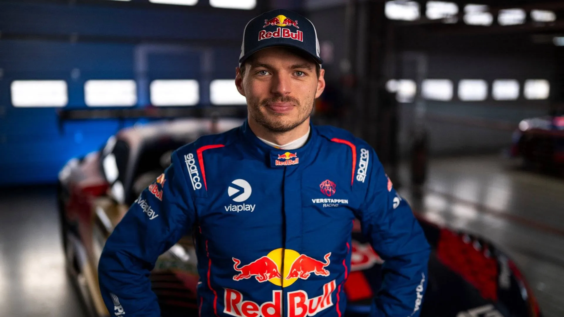 verstappen-endurance in primo piano il pilota dentro a un box, sullo sfondo l'auto da corsa