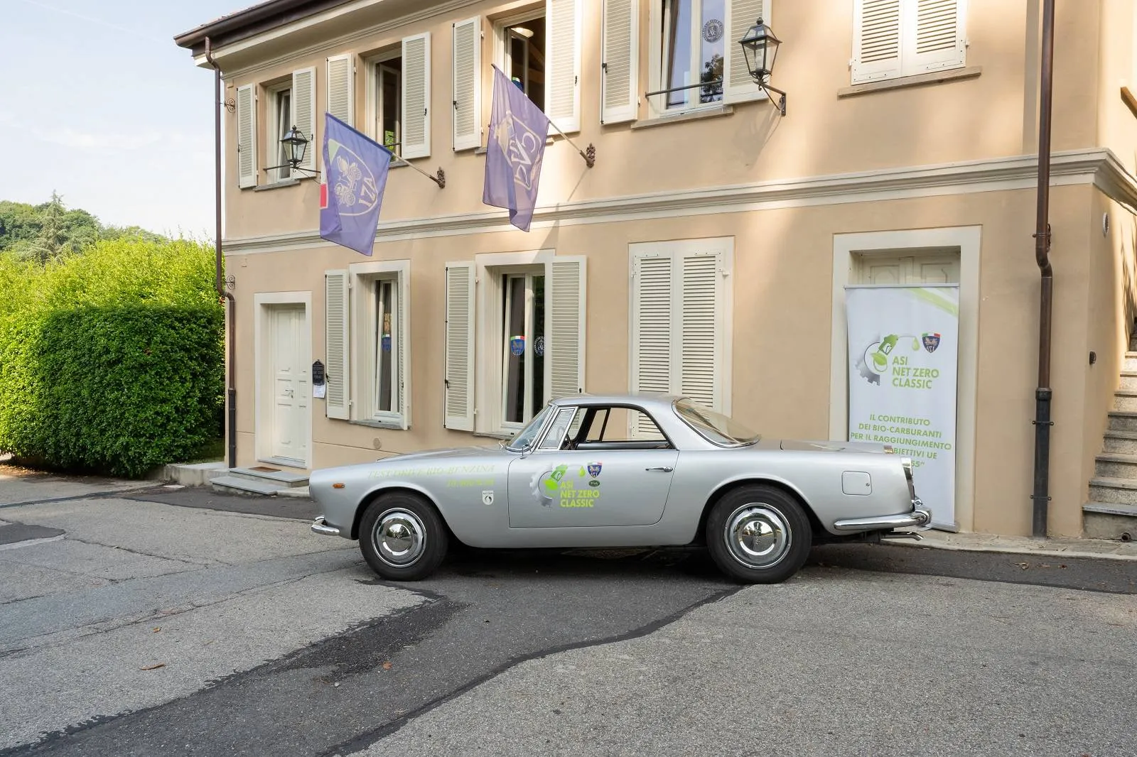 Lancia Flaminia ASI biocarburante a villa sassi torino con sfondo bandiere tre quarti posteriore